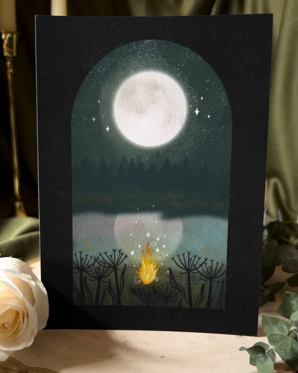 An art print depicting a gentle bonfire beneath a bright full moon.