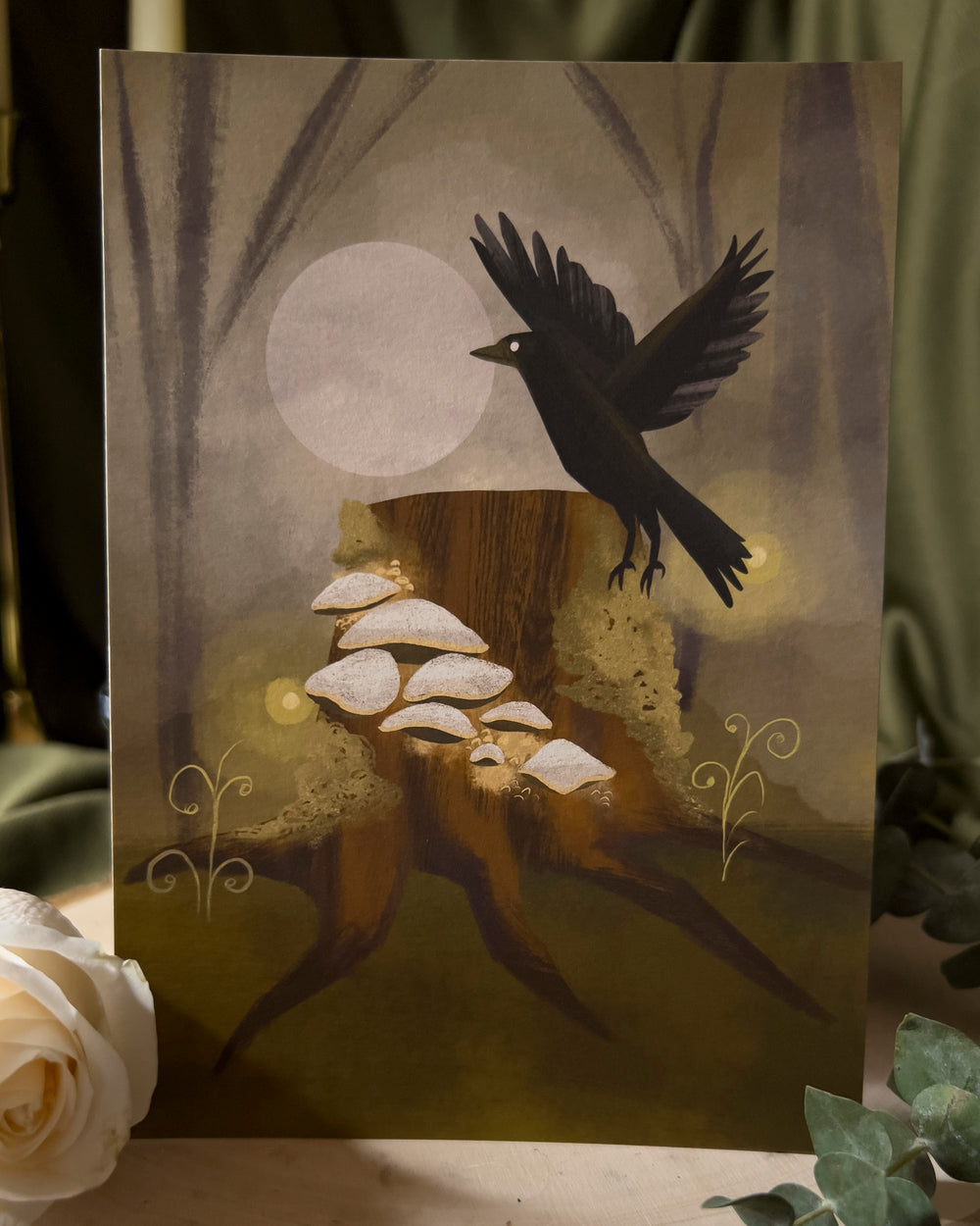 An art print depicting a raven flying near a tree stump that's growing mushrooms.