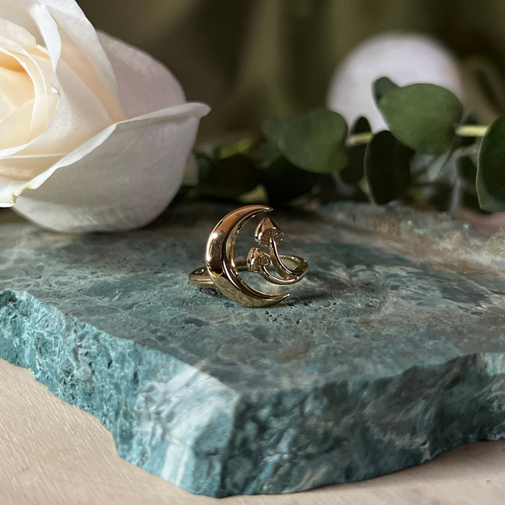 An adjustable ring depicting a moon and a mushroom in bronze.