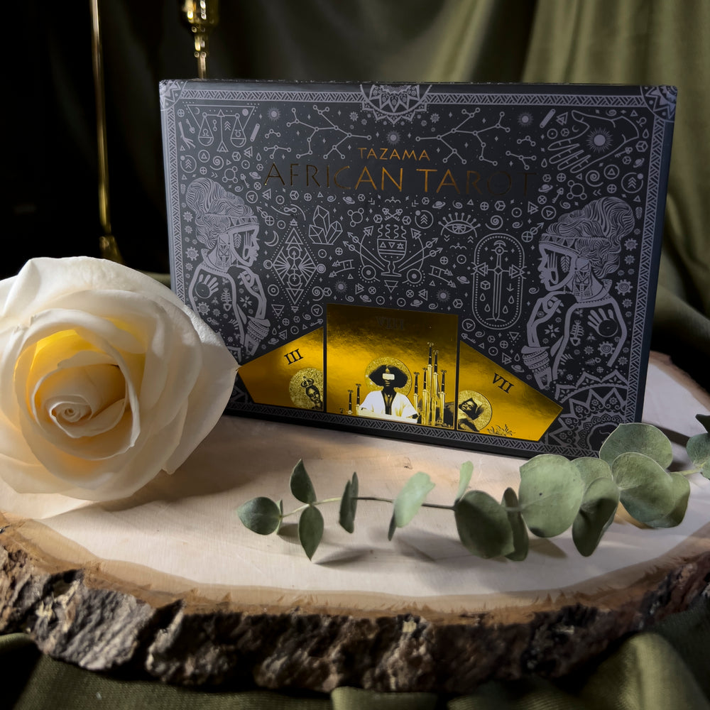 The Tazama Tarot box with mixed grey mystical symbols and gold filigree.