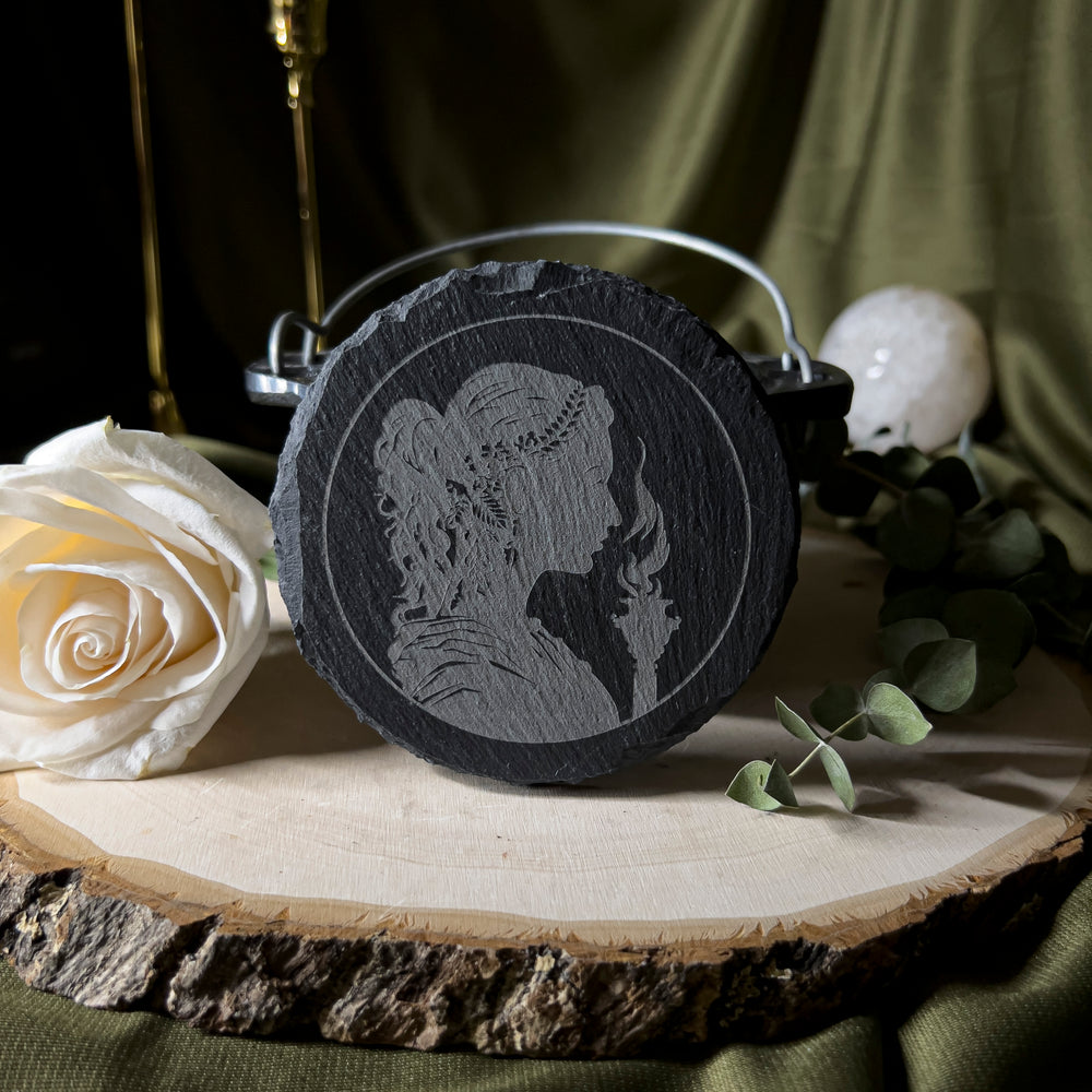 Round slate tile with a carved depiction of Hekate.