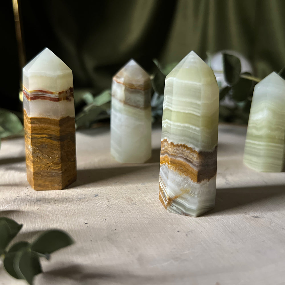 Small green onyx towers with brown and white banding, close up.