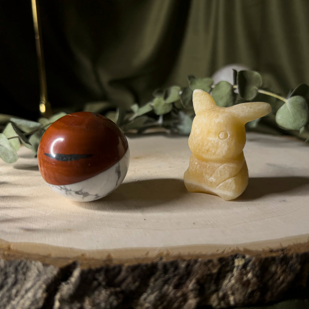 Orange calcite pikachu with a howlite and red jasper pokeball.