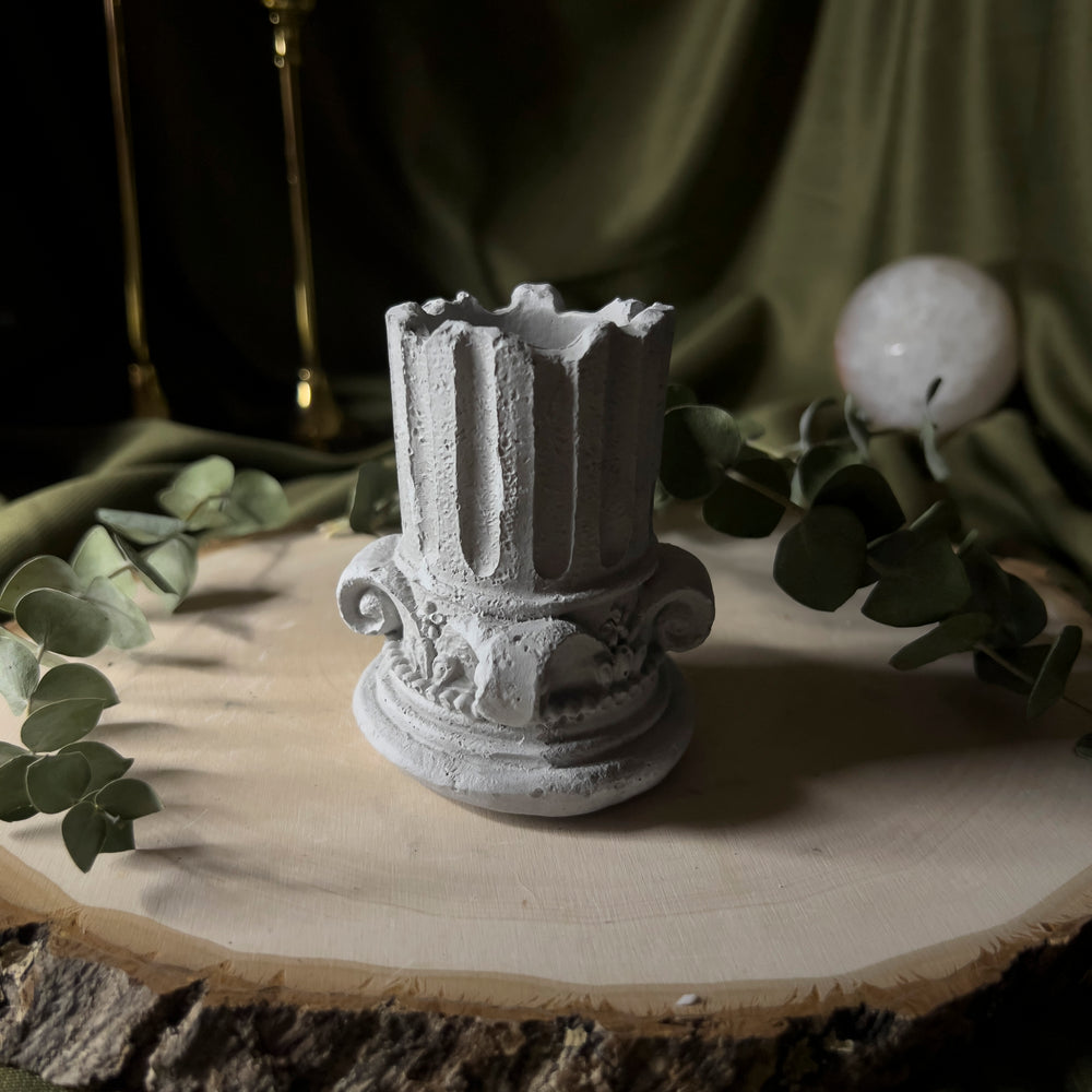 Grey holder shaped like half of a greek column.