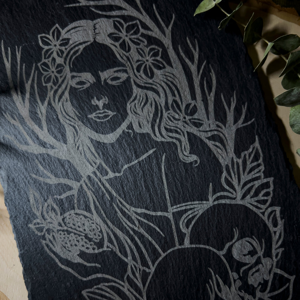 Slate art depicting Queen Persephone with her skulls and pomegranate.