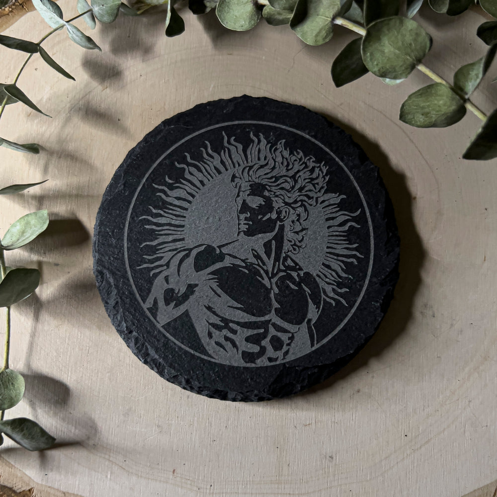 Round slate tile with a carved depiction of Apollon, close up.
